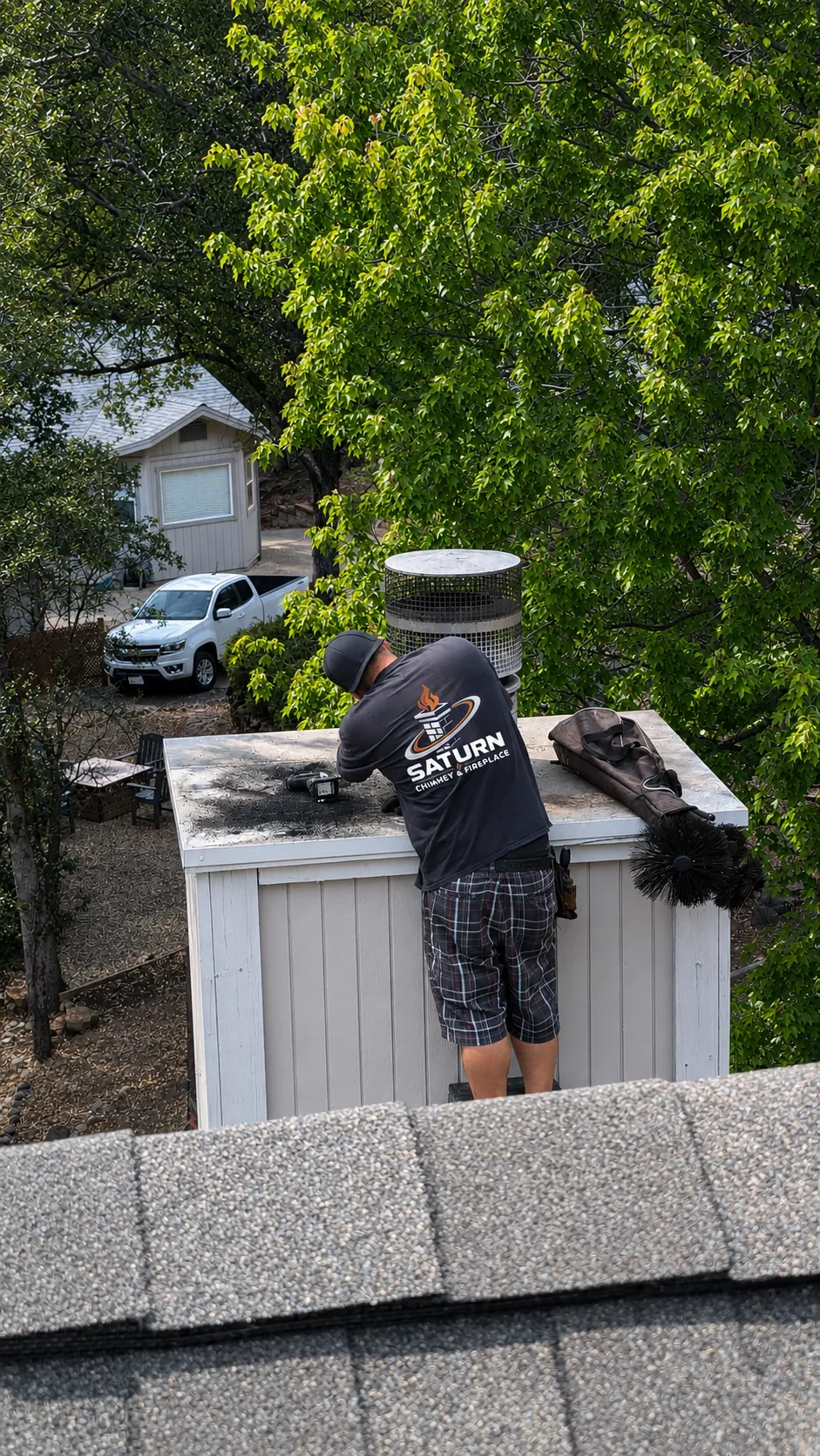 Saturn technician servicing a chimney cap on a residential roof