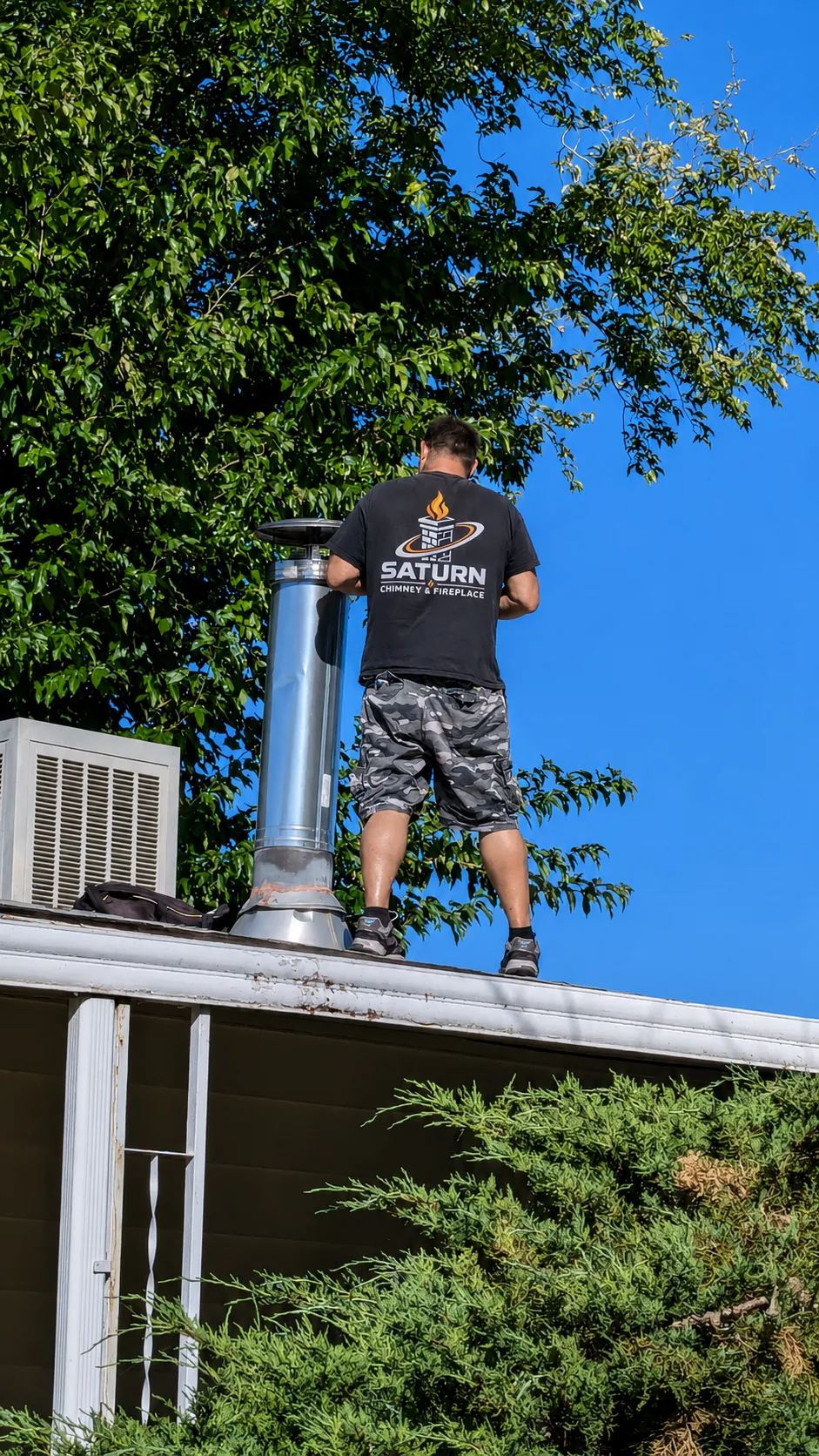 Saturn Chimney & Fireplace technician installing a metal chimney flue